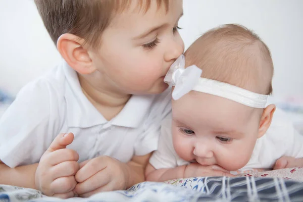 Cute Boy kisses his baby sister. — Stockfoto