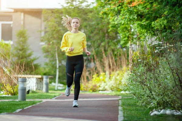 La donna sportiva in giallo si allena in un ambiente urbano . — Foto Stock