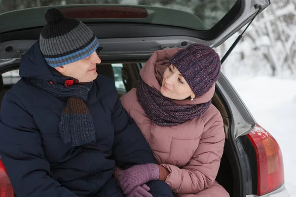 Kochający małżeństwo siedzieć w samochodzie w zimie. — Zdjęcie stockowe