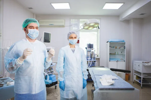 Asistente médico ayuda a un cirujano . —  Fotos de Stock