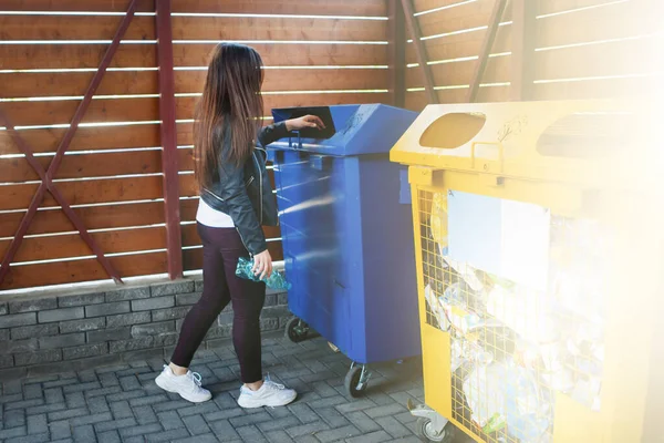 Woman throwing plastic cup into trash can. — Stock Photo, Image