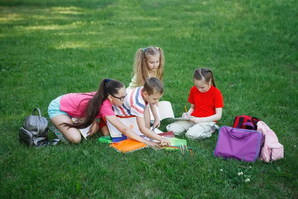 Vier kinderen zittend op het groene gras. — Stockfoto