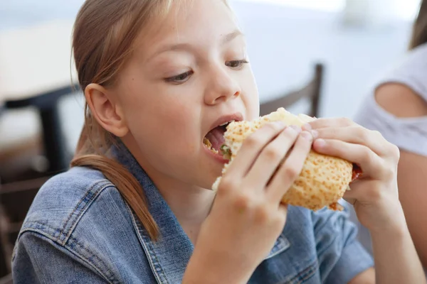 Meisjes tieners aan een tafel in een cafe eten sandwiches en drinken zo — Stockfoto