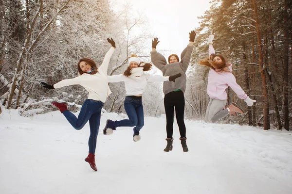 Fyra unga, vackra kvinnor i en snöig skog. — Stockfoto