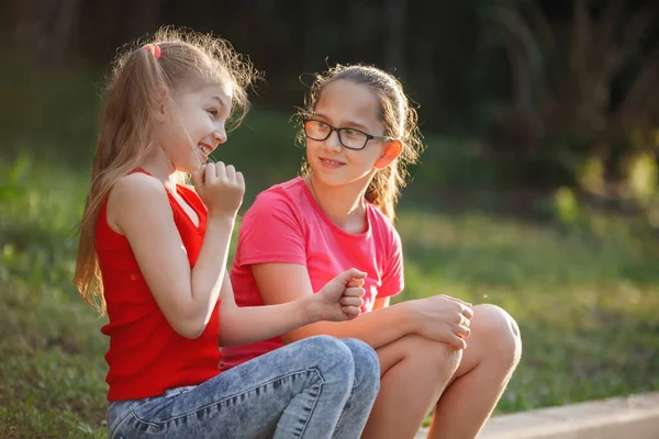 Duas meninas adolescentes rir e falar no parque da cidade . — Fotografia de Stock