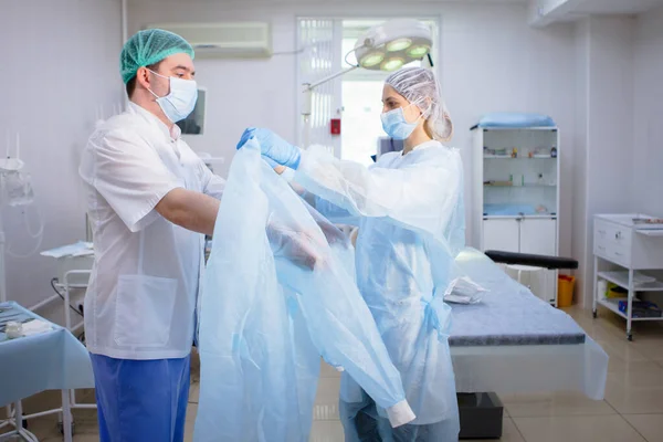 Asistente médico ayuda a un cirujano . —  Fotos de Stock