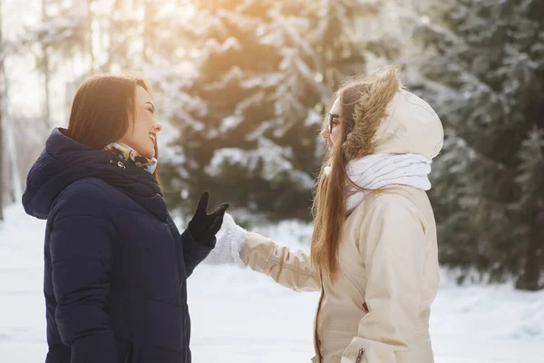 Deux jeunes jolies femmes dans une forêt enneigée . — Photo