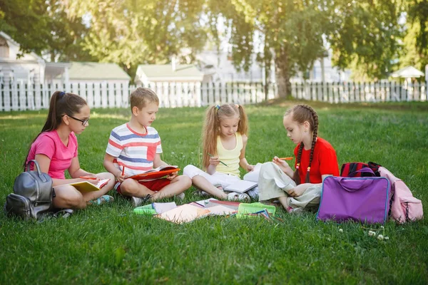 Quatre enfants assis sur l'herbe verte . — Photo