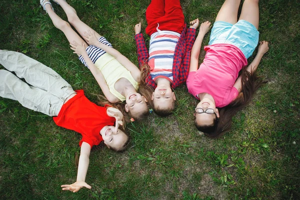 Crianças deitadas na grama verde . — Fotografia de Stock