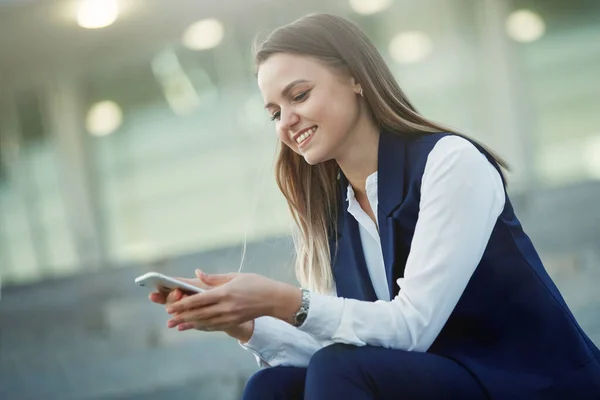 Jovem mulher bonita com smartphone Olha para o telefone . — Fotografia de Stock