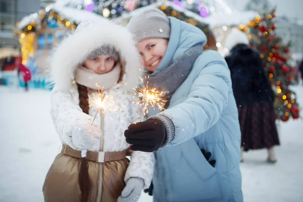 Kış giysileri içinde Noel maytaplı bir kadın ve genç kız. — Stok fotoğraf