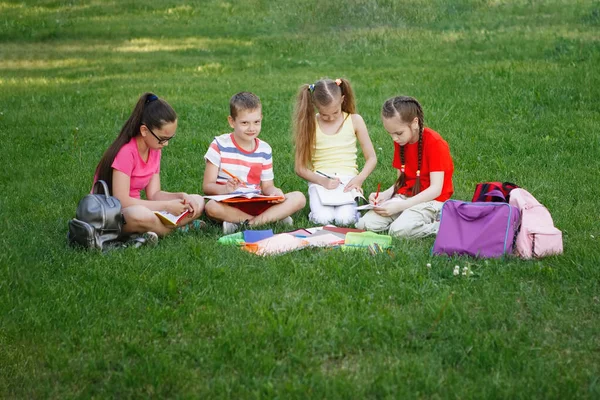Четверо детей сидят на зеленой траве . — стоковое фото