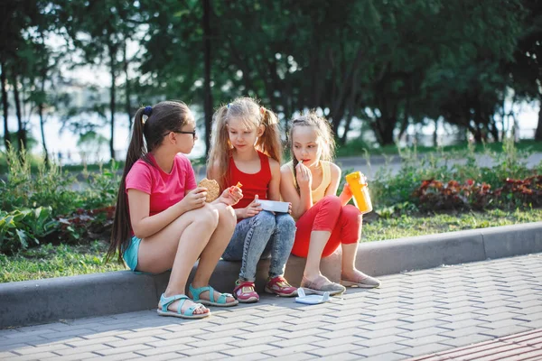 Tieners zitten op de stoep in het stadspark. — Stockfoto