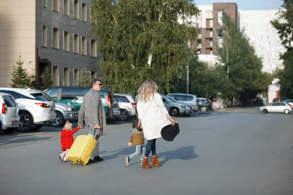 Gezin met gele koffer — Stockfoto