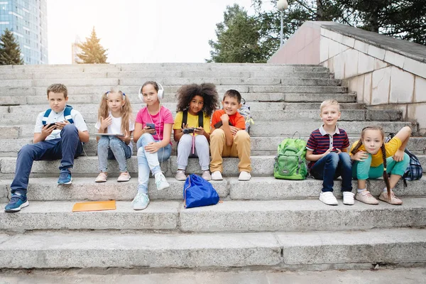 Groupe d'écoliers assis sur les marches de l'école — Photo