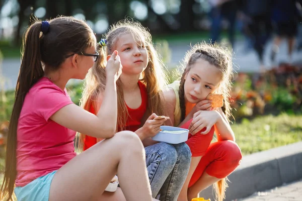 Adolescents assis sur le trottoir dans le parc de la ville . — Photo