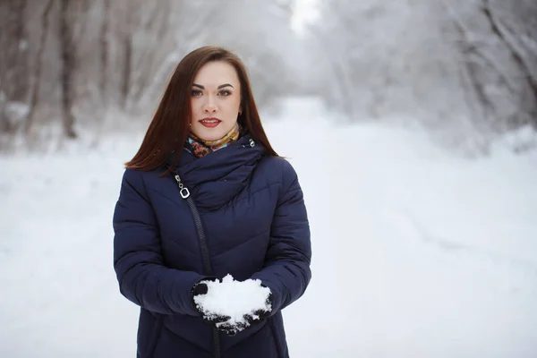 Νέα, όμορφη γυναίκα με μπλε φουλάρι και σακάκι σε ένα χιονισμένο δάσος — Φωτογραφία Αρχείου