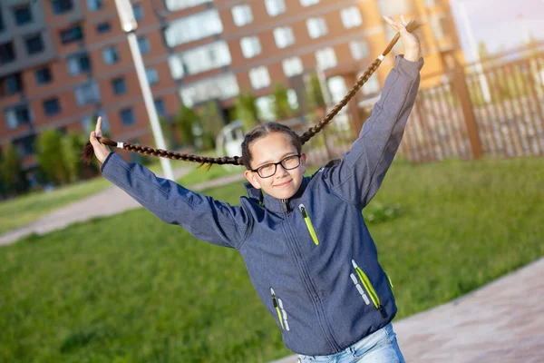 Dívka teenager hraje s copánky. — Stock fotografie