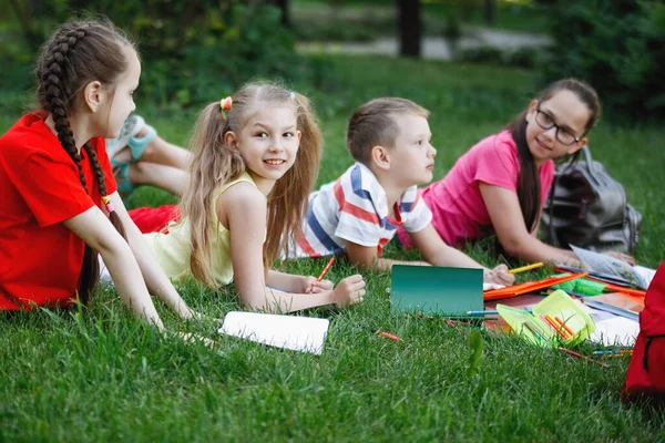 Enfants couchés sur l'herbe verte . — Photo