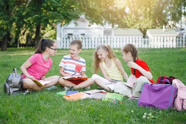 Quatre enfants assis sur l'herbe verte . — Photo