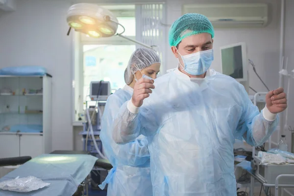 Asistente médico ayuda a un cirujano . —  Fotos de Stock