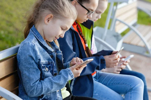 Enfants et gadgets dans le parc de la ville . — Photo