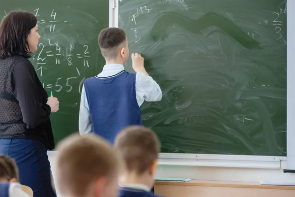 Schoolchildren in the classroom at the lesson.