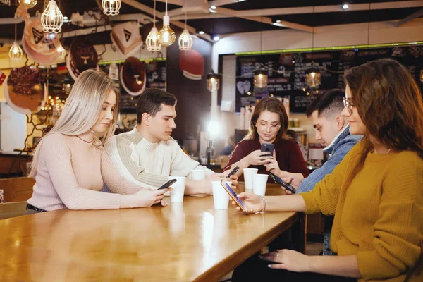Cinco jóvenes estudiantes guapos sentados en un café . Imagen de archivo