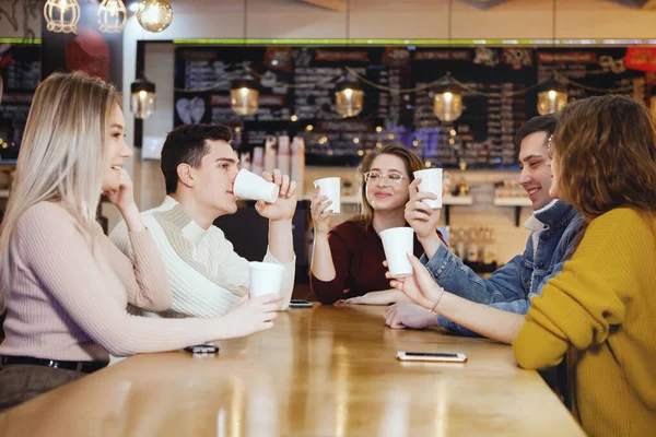 Cinco jóvenes estudiantes guapos sentados en un café . Imagen de stock