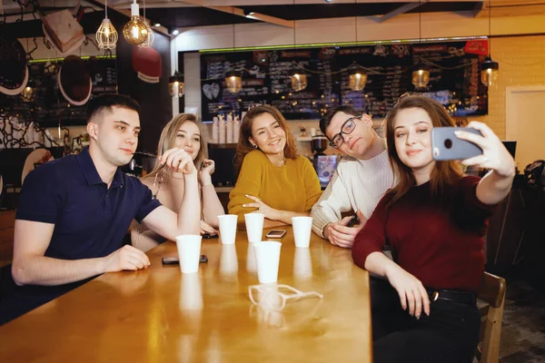 Cinco jóvenes estudiantes guapos sentados en un café . Imagen de stock