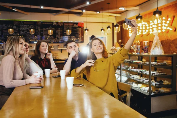 Cinco jóvenes estudiantes guapos sentados en un café . Imágenes de stock libres de derechos