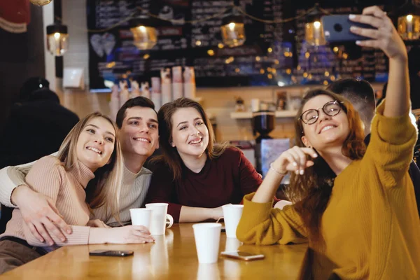 Cinco jóvenes estudiantes guapos sentados en un café . Fotos de stock libres de derechos