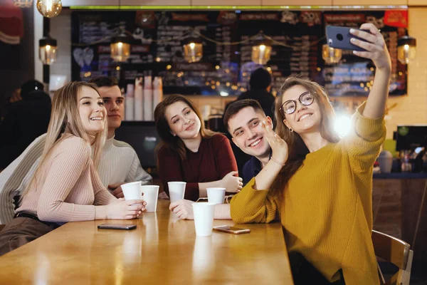 Cinco jóvenes estudiantes guapos sentados en un café . Fotos de stock