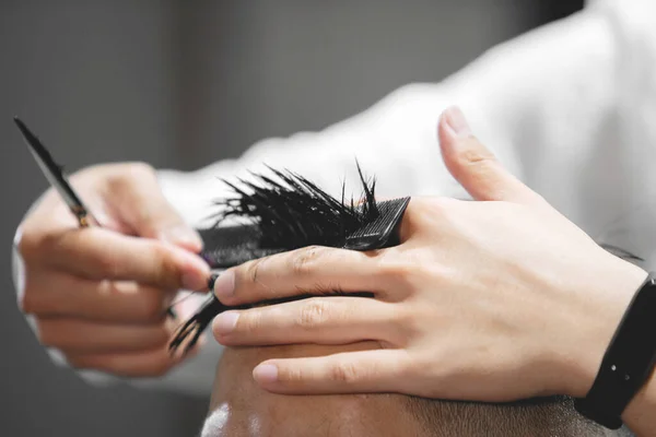 小伙子在美容院里用剪刀剪头发 — 图库照片