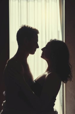 Siluet İki aşık adam ve kadın sarılıyor.