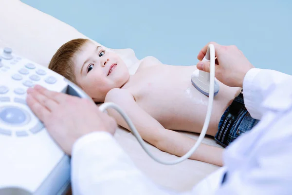 Çocuğun ultrason muayenesi. Doktor, klinikteki bir çocuğun karın taramasını yapıyor..