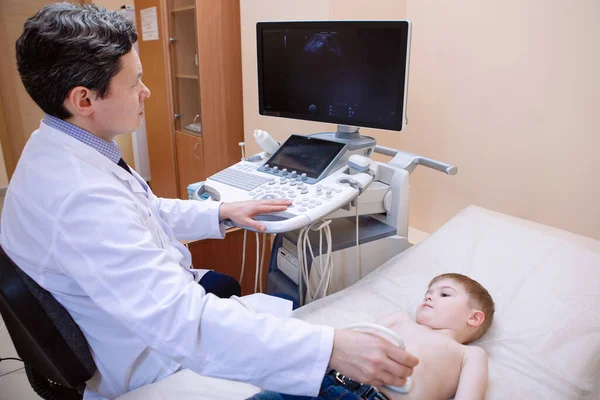 子供の超音波検査 医者は診療所で少年の腹部スキャンを行います — ストック写真