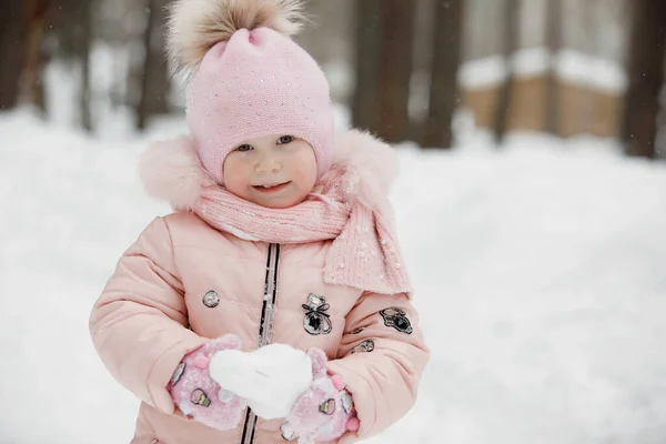 Dziewczynka Różowym Kombinezonie Czapce Pomponem Bawi Się Białą Śnieżką Słoneczny — Zdjęcie stockowe