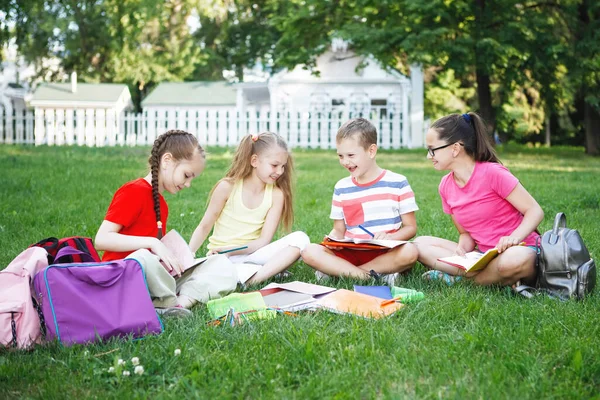 Quatro Crianças Sentadas Relva Verde Adolescentes Ler Desenhar Gramado Parque — Fotografia de Stock