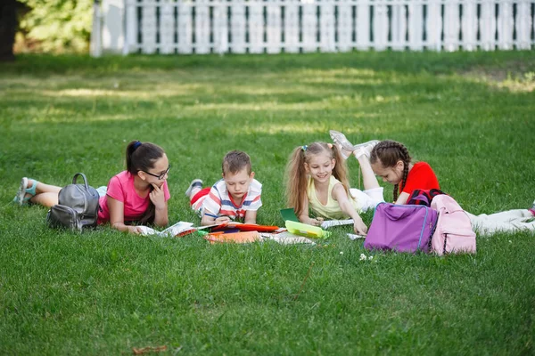 Quatre Enfants Sont Couchés Sur Herbe Sur Pelouse Dans Parc — Photo