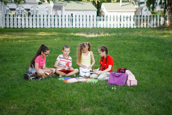 Quatre Enfants Assis Sur Herbe Verte Les Adolescents Lisent Dessinent — Photo