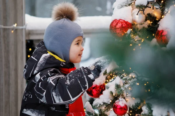 Boy Hat Pompom Looks Toys Christmas Tree Outdoors — Stock Photo, Image