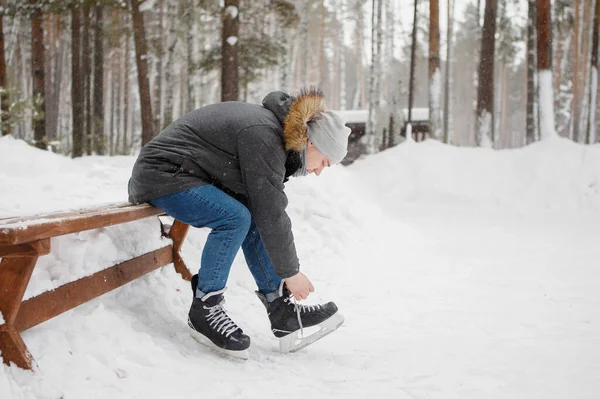 Jovem Lace Patins Sentado Banco Perto Parque Inverno Pista Gelo — Fotografia de Stock