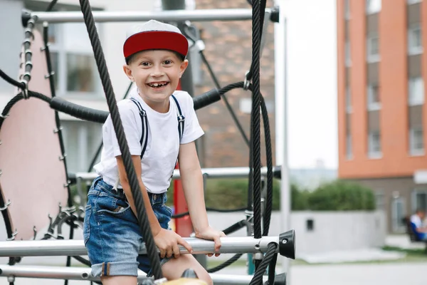 Junge Klettert Auf Das Seilgerät Städtischen Spielplatz Weißes Hemd Mütze — Stockfoto