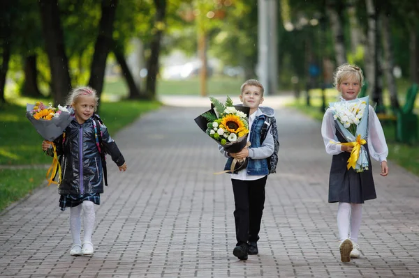 Городском Парке Прогуливаются Школьники Мальчик Девочки Букетами Цветов Начале Учебного — стоковое фото