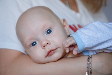 Anne bebeği kollarında tutuyor. Ebeveyn sevgisi, annelik, bakım.