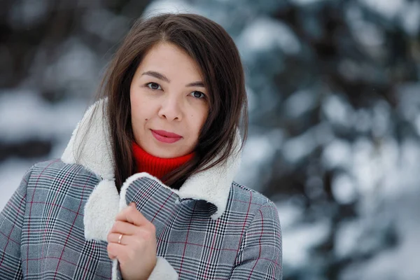 Pěkná Žena Šedém Kabátě Pózuje Zimě Rozmazaném Zasněženém Pozadí — Stock fotografie