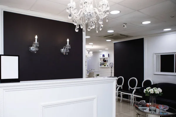 Beauty Salon Interior. Black and white gamma. Entrance hall with reception desk and sofa.
