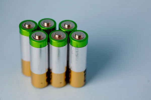 6 AA alkaline batteries are in a row. Blue background. Symbol of clean energy. Eco friendly