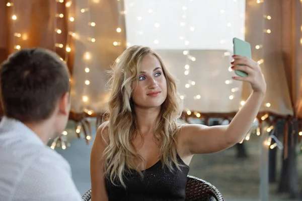 Long Haired Blonde Girl Makes Selfie Smartphone Cafe Background Blurry — Stock Photo, Image